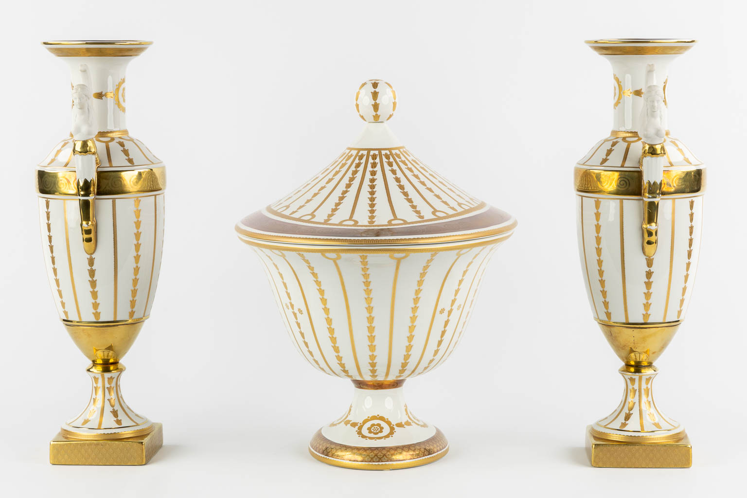 Mangani, Italy, a three-piece garniture, gilt porcelain in Empire style. (L:32 x W:43 x H:40 cm)