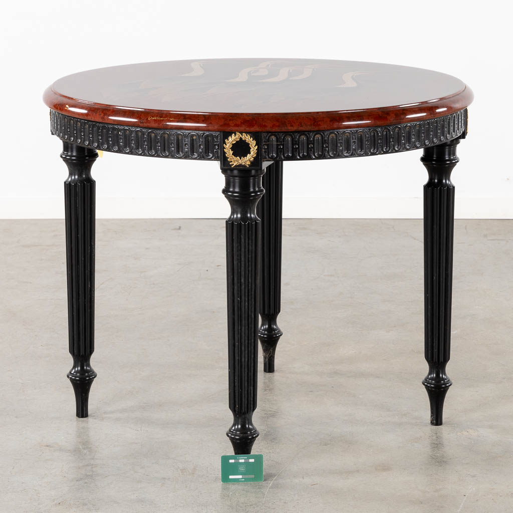 A decorative table with 'Cranes' decor, on a Louis XVI style table base.