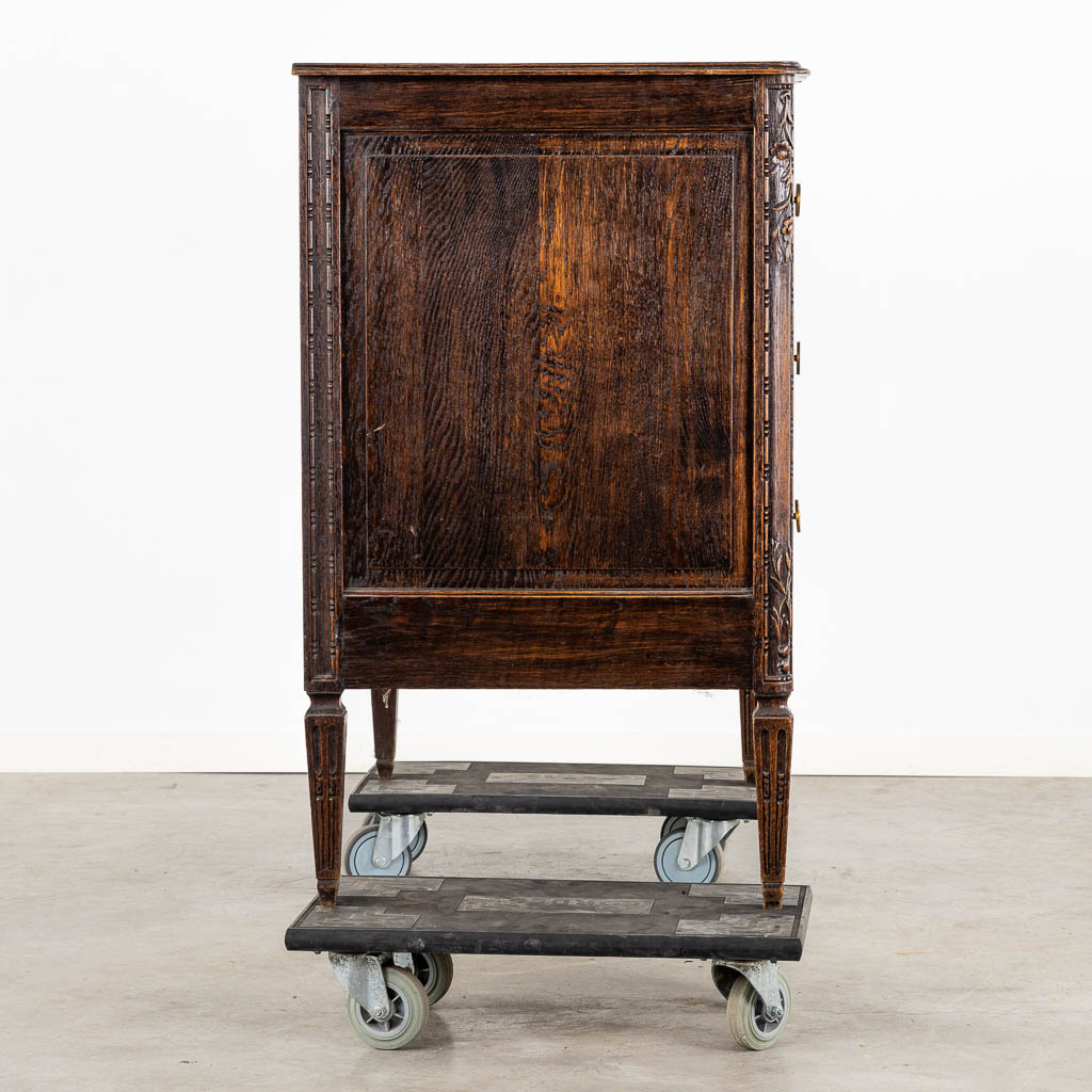 A three-drawer commode, floral wood-sculptures in a Louis XVI style. (L:60 x W:110 x H:99 cm)