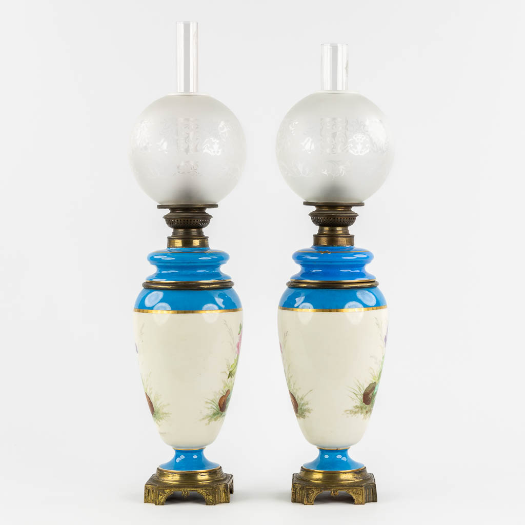 A pair of oil lamps, hand-painted porcelain. 19th C. (H:69 cm)