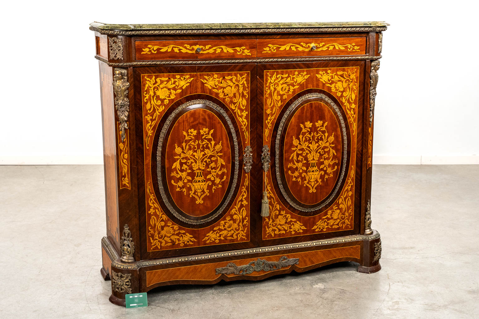 A two-door marquetry inlay cabinet, mounted with bronze and a marble. 20th C.