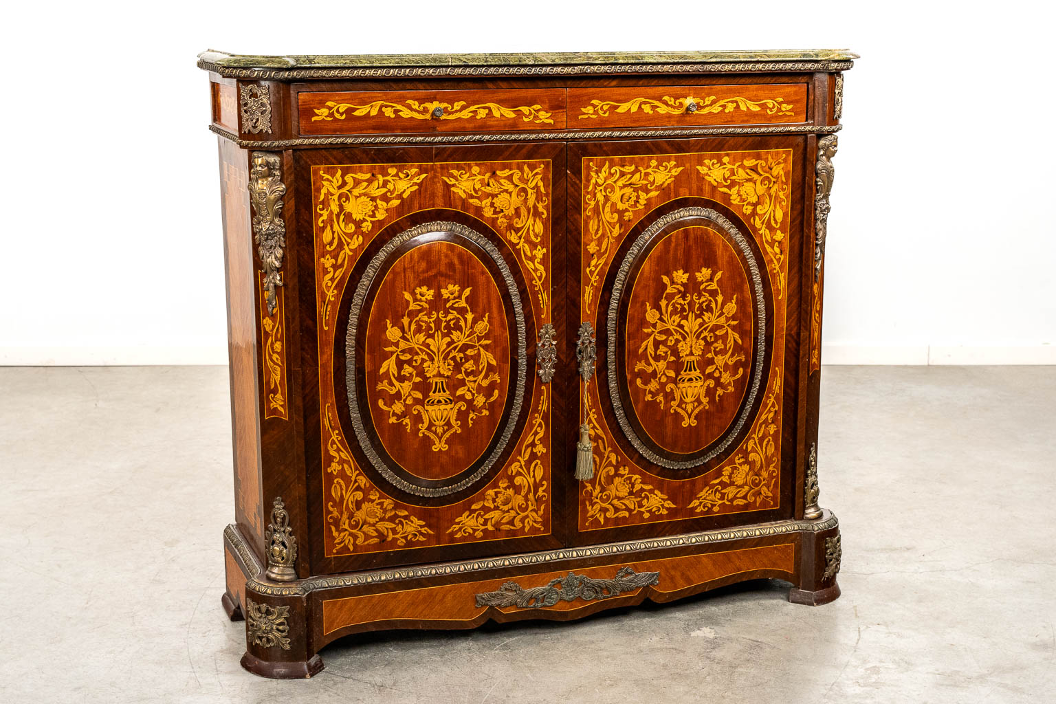 A two-door marquetry inlay cabinet, mounted with bronze and a marble. 20th C.