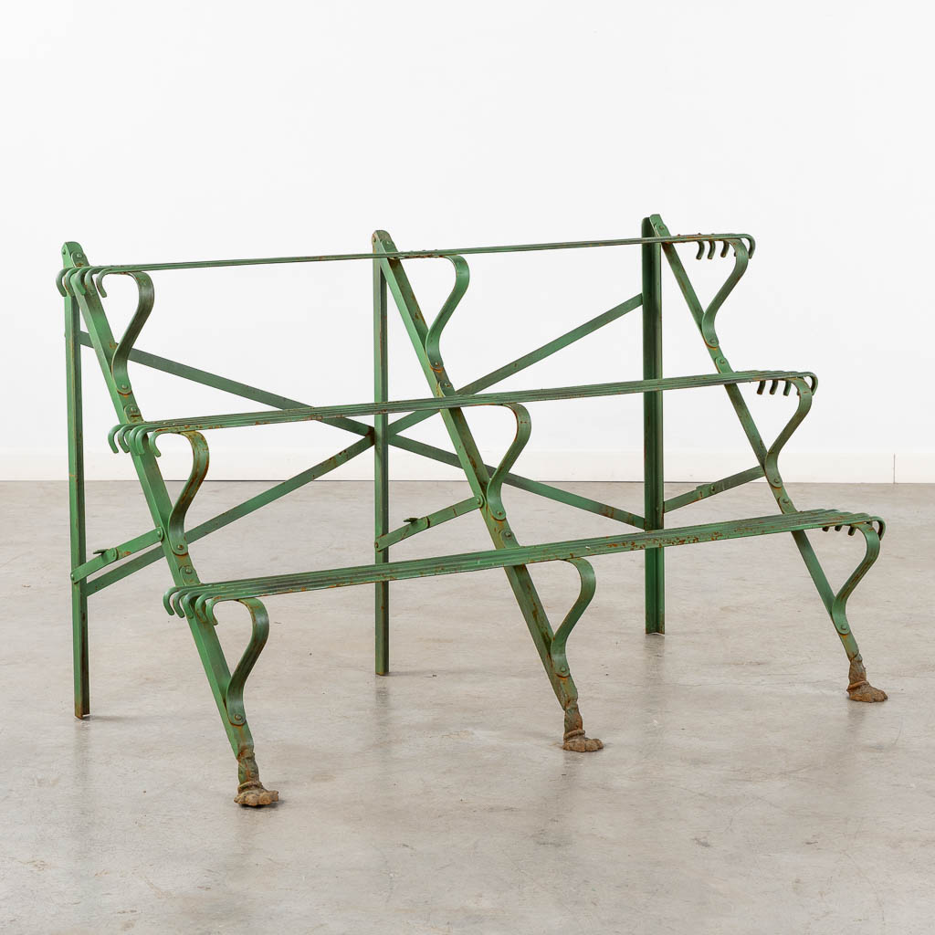 A green-patinated metal garden rack standing on claw feet. (L:60 x W:124 x H:75 cm)