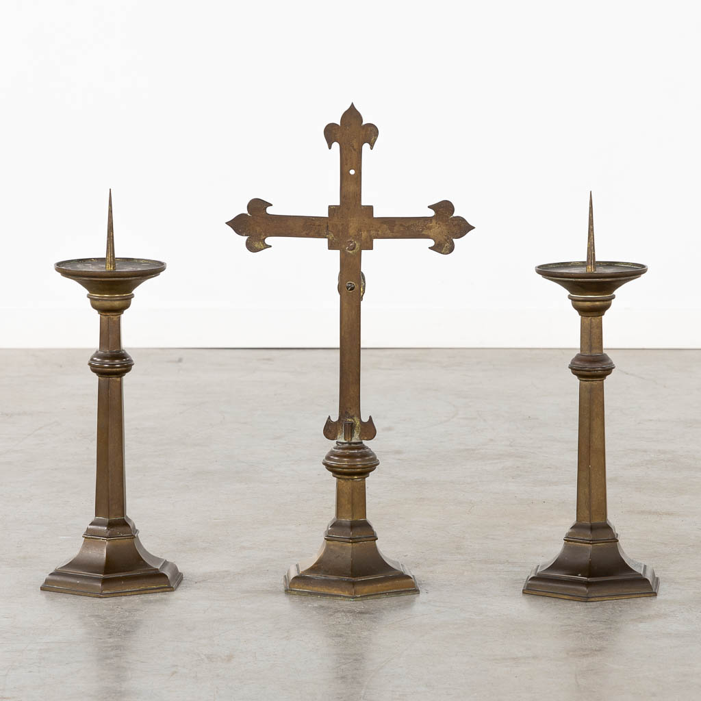 An altar crucifix with two matching candelabra, patinated bronze. Gothic Revival, Circa 1900. (W:29,5 x H:58 cm)