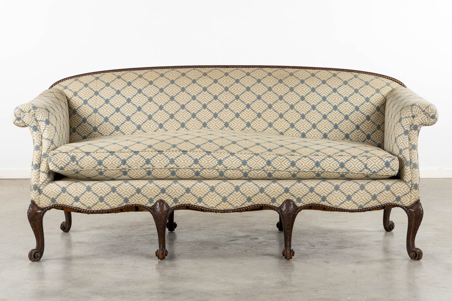 A sculptured mahogany settee with matching pillows, Louis XV style. (L:85 x W:205 x H:90 cm)