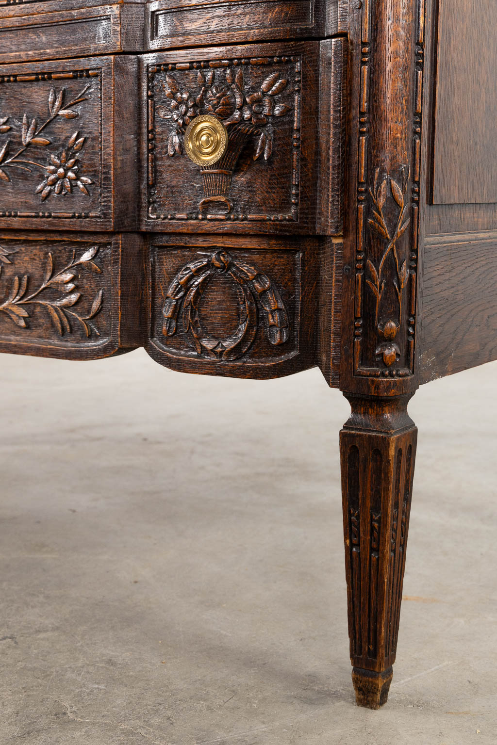 A three-drawer commode, floral wood-sculptures in a Louis XVI style. (L:60 x W:110 x H:99 cm)