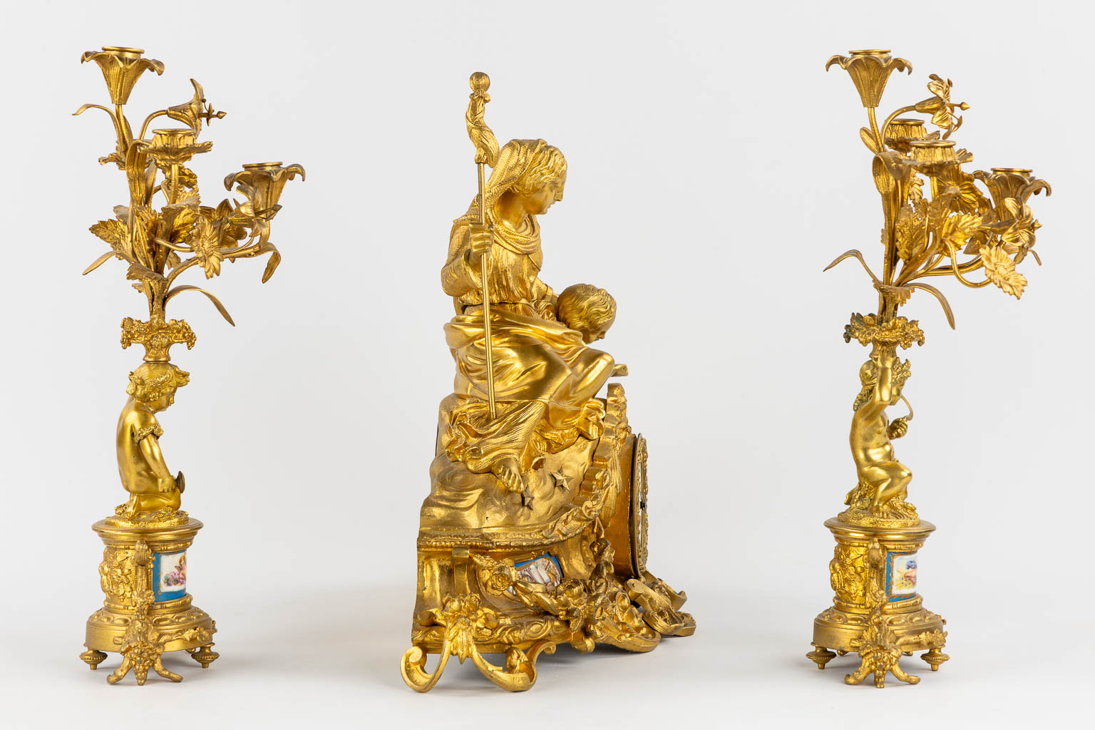 A three-piece mantle garniture clock and candelabra, gilt bronze and Sèvres porcelain, 19th C. (L:20 x W:53 x H:52 cm)