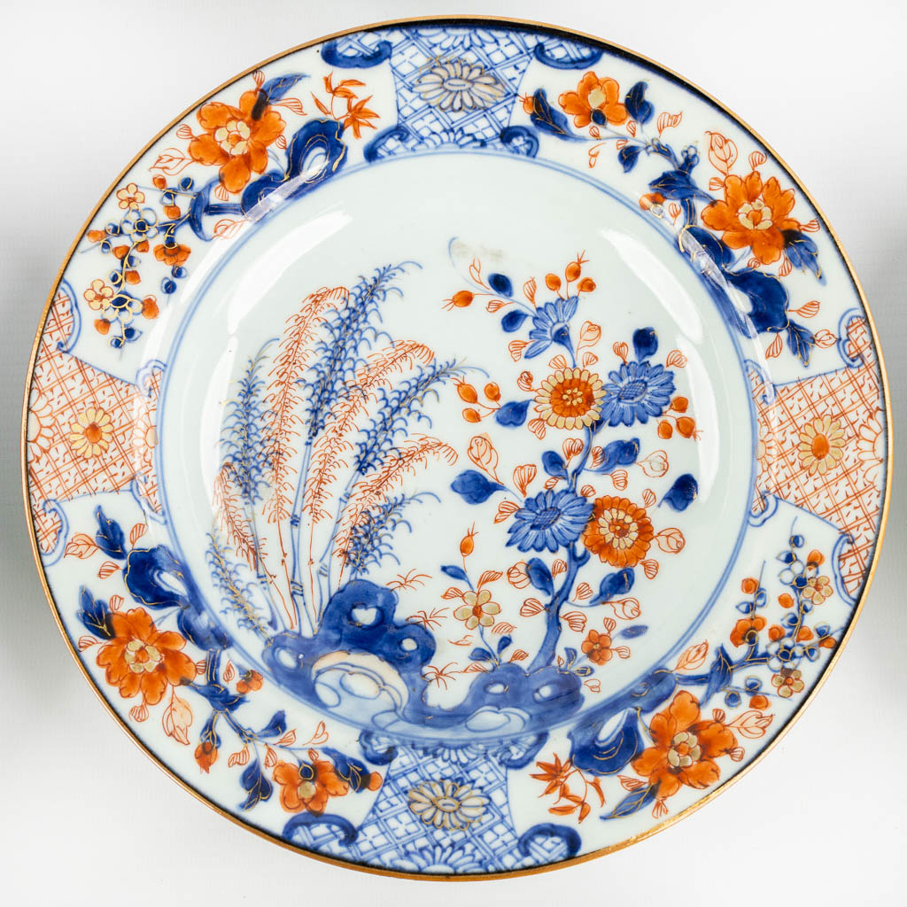 Negen Chinese Imari stijl borden met een floraal decor. 18de eeuw. (D:23 cm)