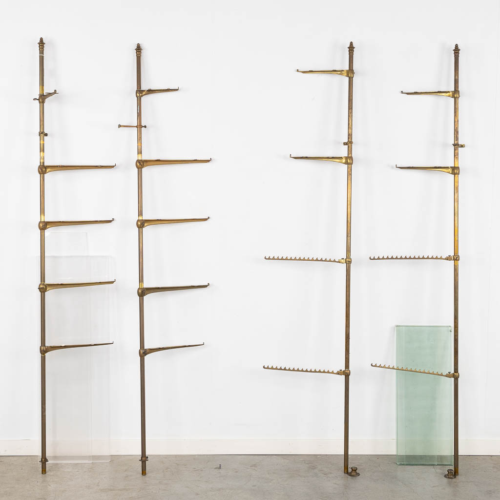 A display rack, brass, glass and plexiglass. Circa 1920. (W:37,5 x H:182 cm)