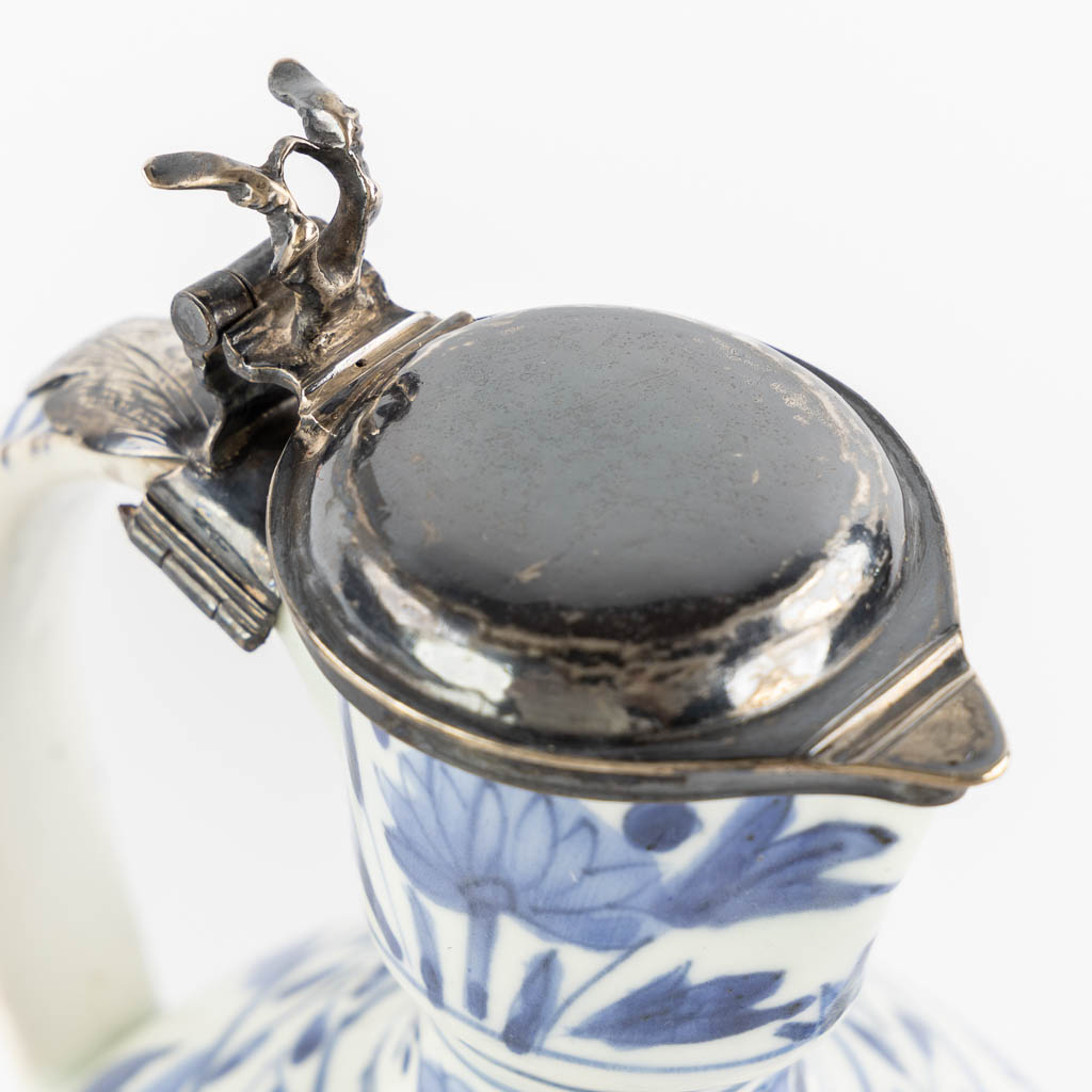 A Chinese pitcher, blue-white mounted with silver, Netherlands, 17th C. (L:12 x W:13 x H:25 cm)