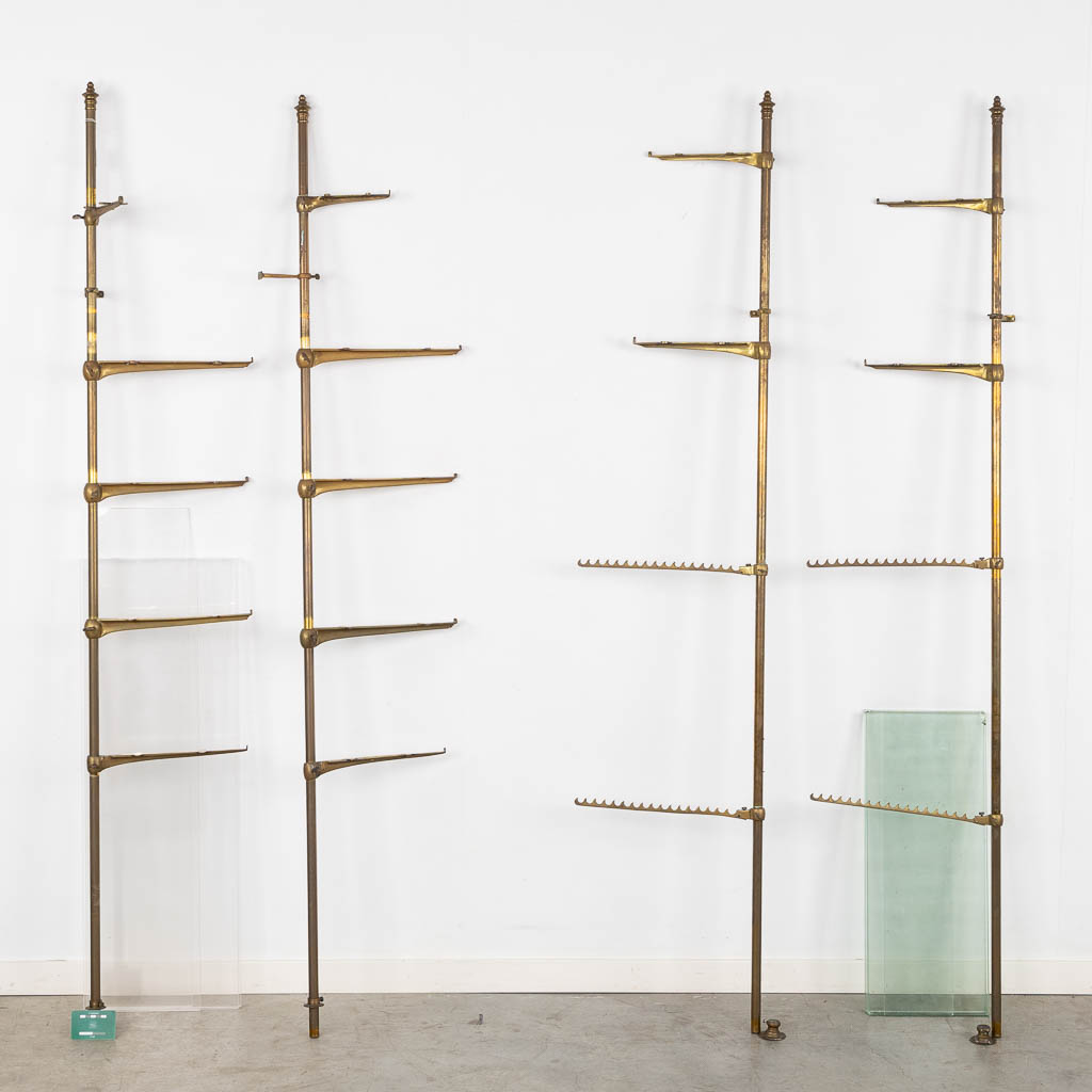 A display rack, brass, glass and plexiglass. Circa 1920. (W:37,5 x H:182 cm)