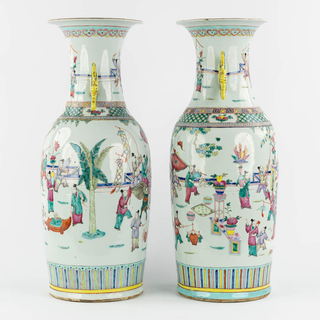 A pair of Chinese Famille Rose vases decorated with various figurines. (H:60 x D:23 cm)