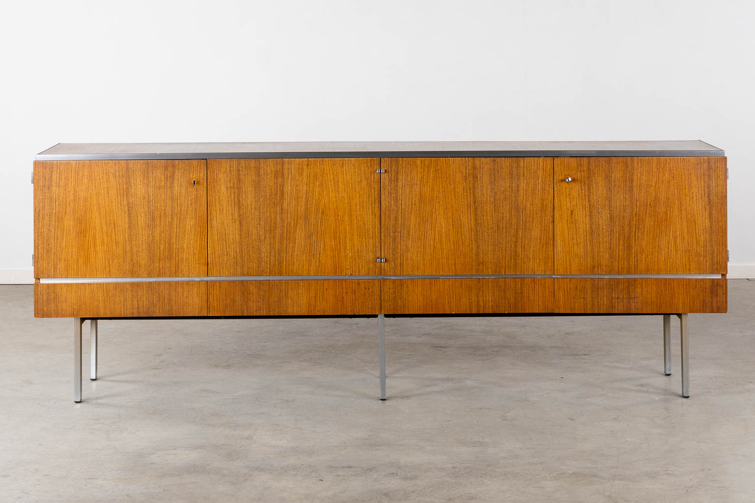 A mid-century sideboard, veneer and chomed metal. By Roger De Winter. (L:46 x W:237 x H:84 cm)