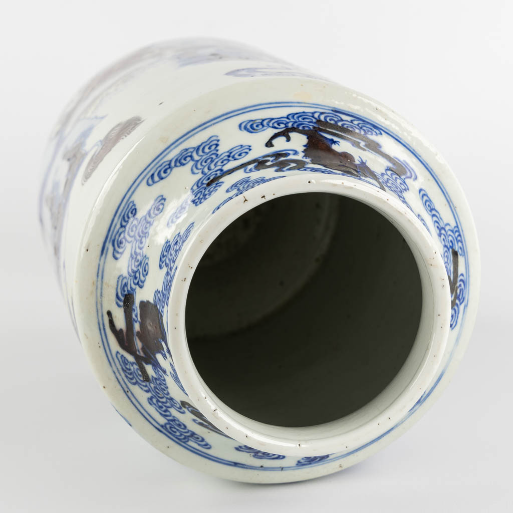 A Chinese Rouleau vase with a blue, black and white Foo Dog. Kangxi mark, 19th C. (H:39 x D:29 cm)