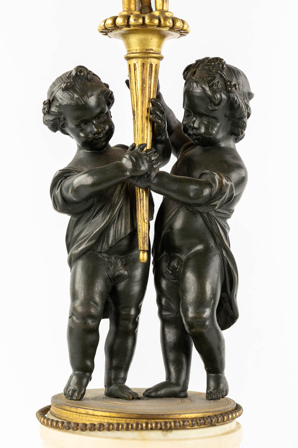 A pair of Marble, gilt and patinated bronze candelabra with putti, Louis XVI style, 19th C. (L:16,5 x W:16,5 x H:71,5 cm)