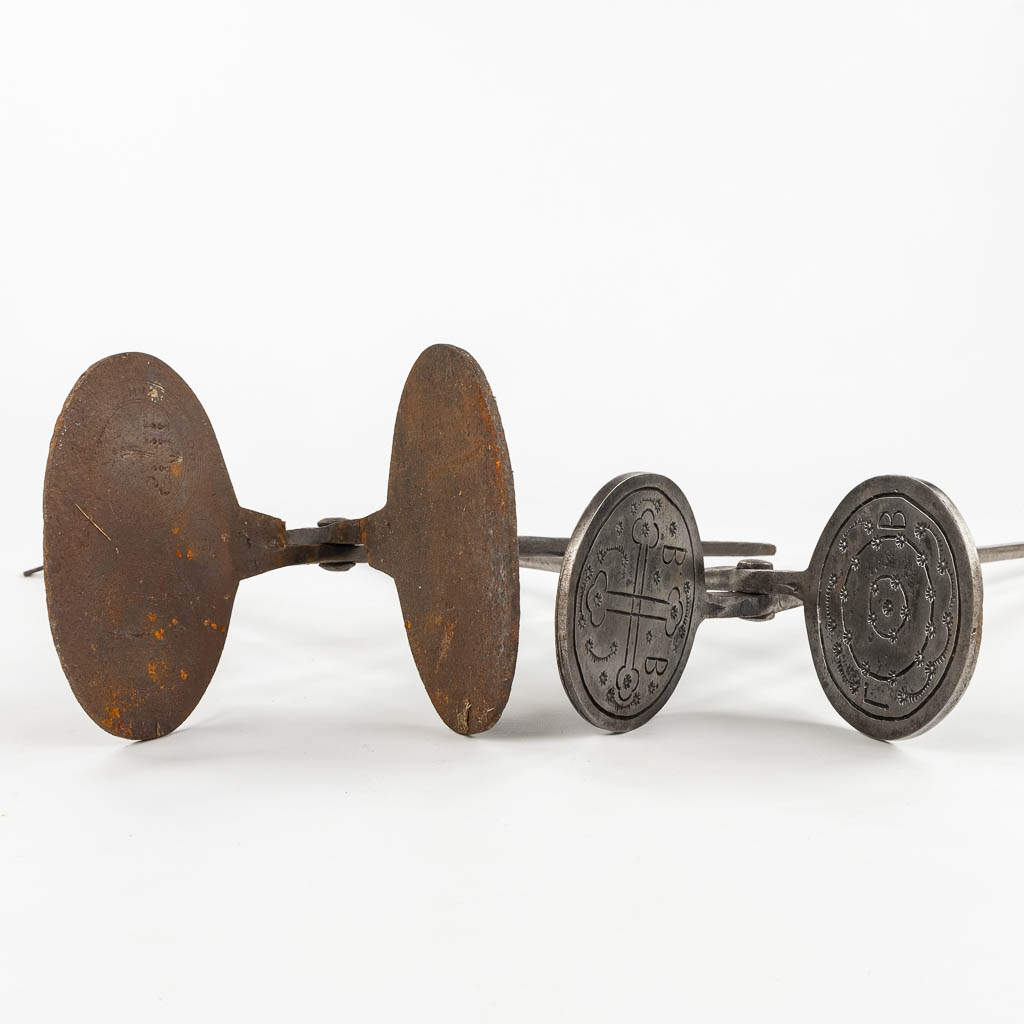 Two 'Sacred Bread' baking forms, wrought iron, circa 1800. (L:103 cm)