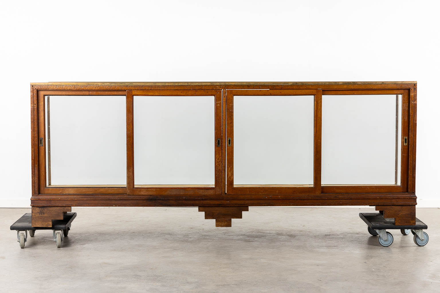 An antique English shop display cabinet, shop counter, Showcase. Brass, wood and glass. (L:62 x W:245 x H:92 cm)