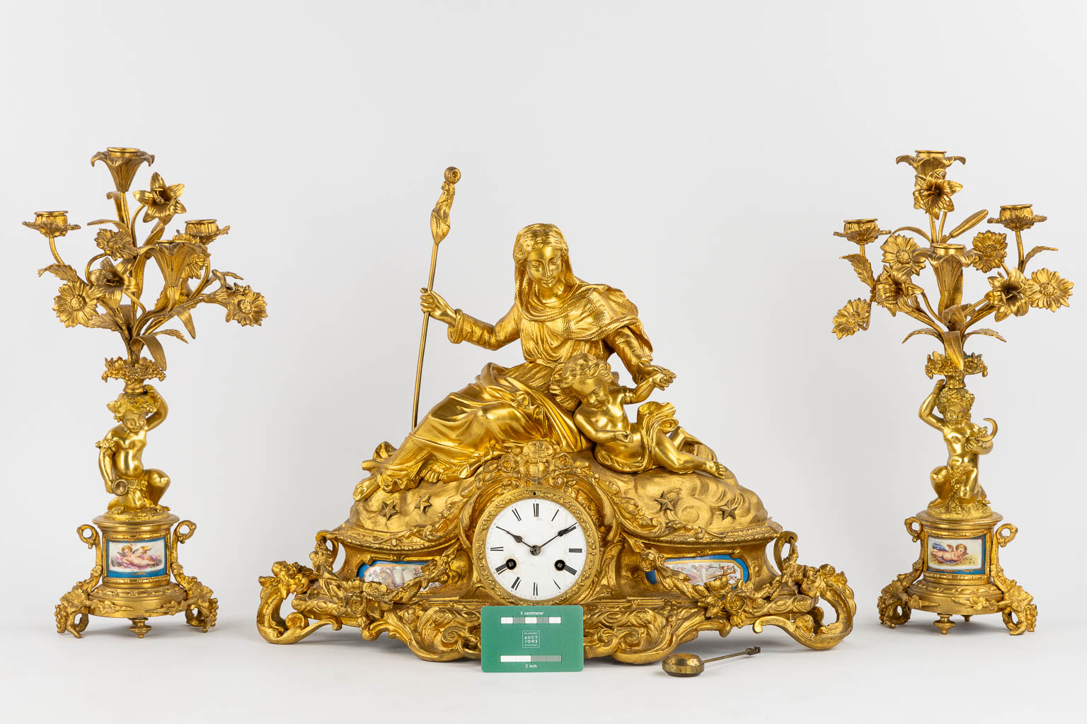 A three-piece mantle garniture clock and candelabra, gilt bronze and Sèvres porcelain, 19th C. (L:20 x W:53 x H:52 cm)