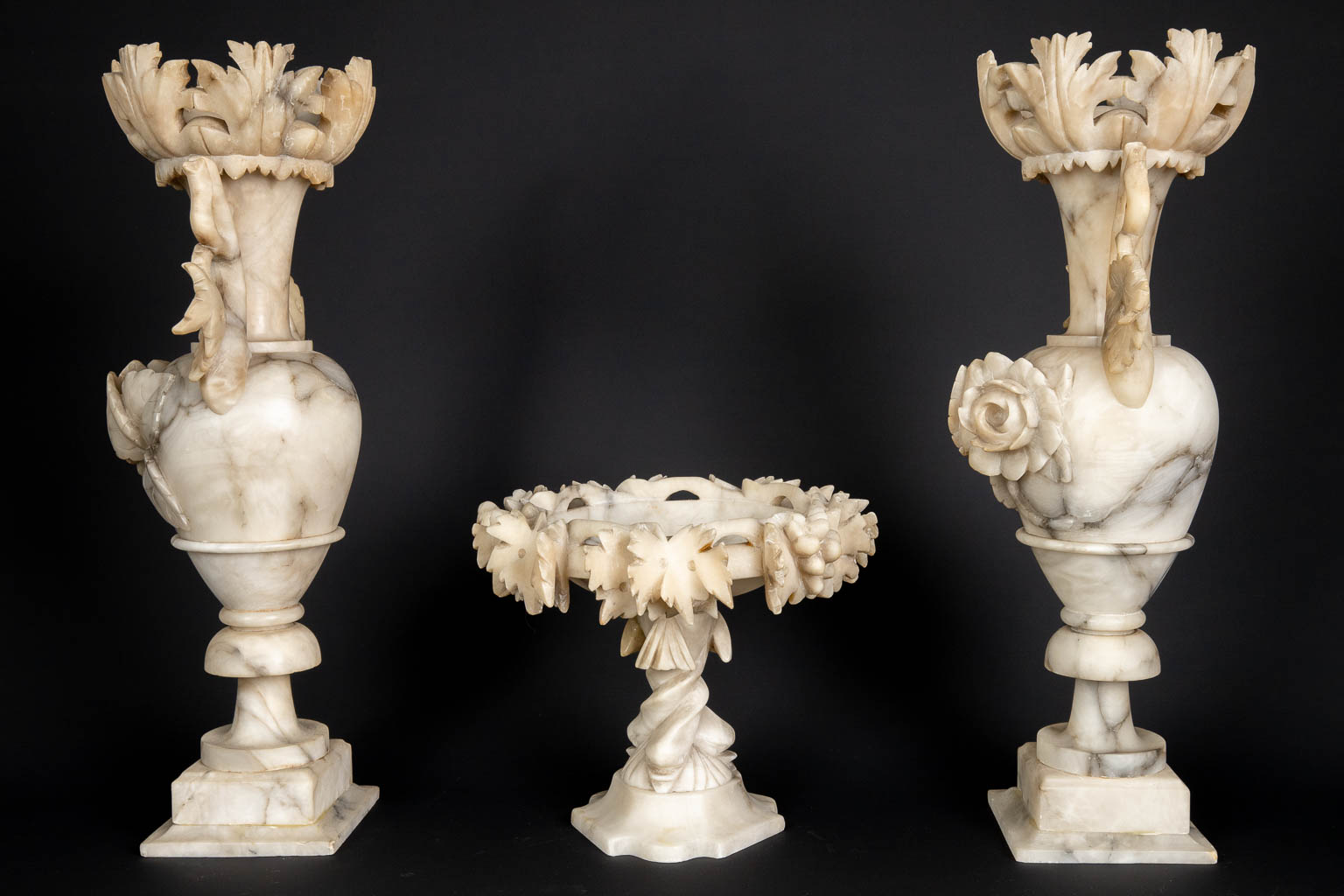 A three piece mantle garniture set, sculptured alabaster. (H:45 x D:15 cm)