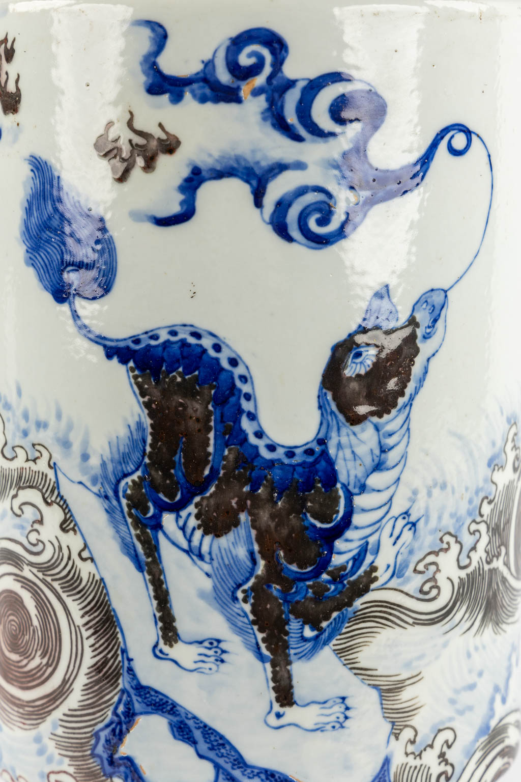 A Chinese Rouleau vase with a blue, black and white Foo Dog. Kangxi mark, 19th C. (H:39 x D:29 cm)