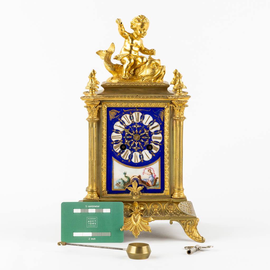 A mantle clock, gilt bronze mounted with porcelain. 19th C.