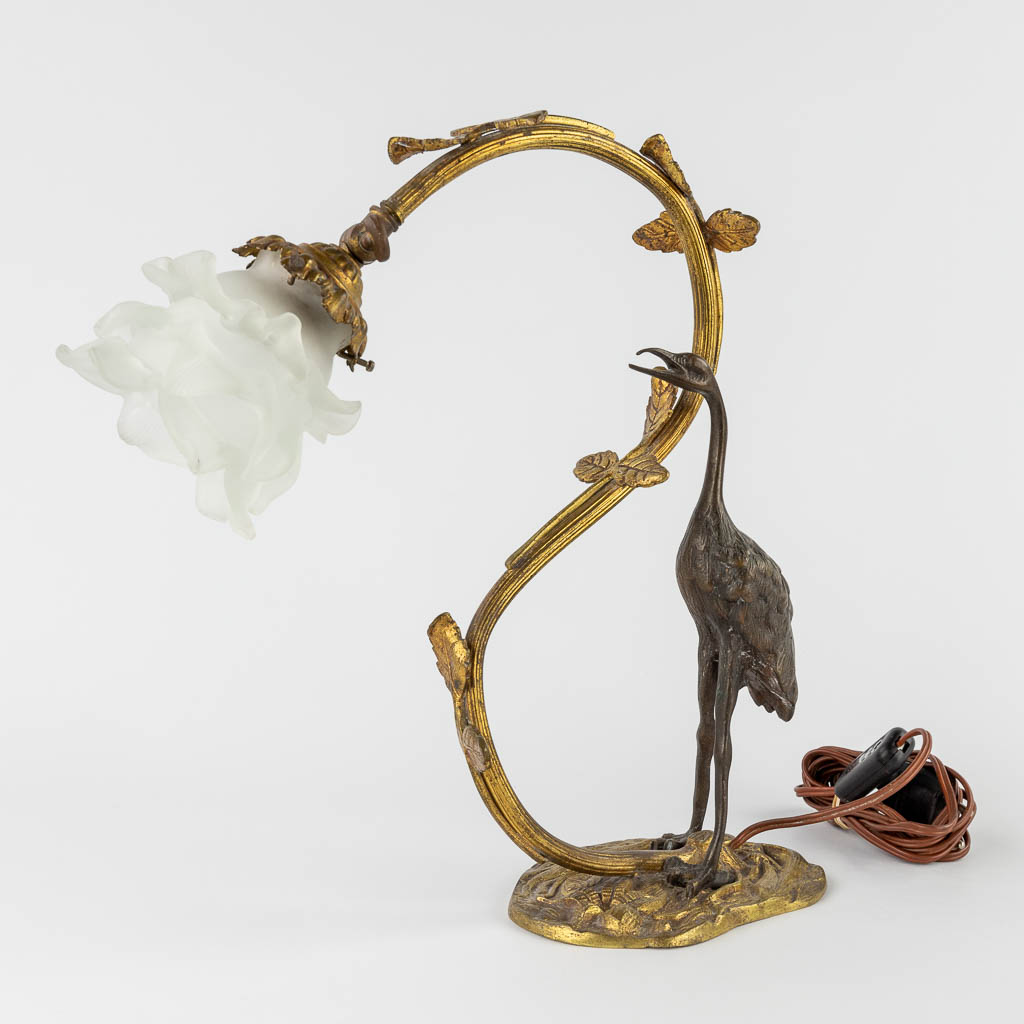 A table lamp with a large bird, probably a Heron. Patinated and gilt bronze, circa 1900. (W:33 x H:37 cm)