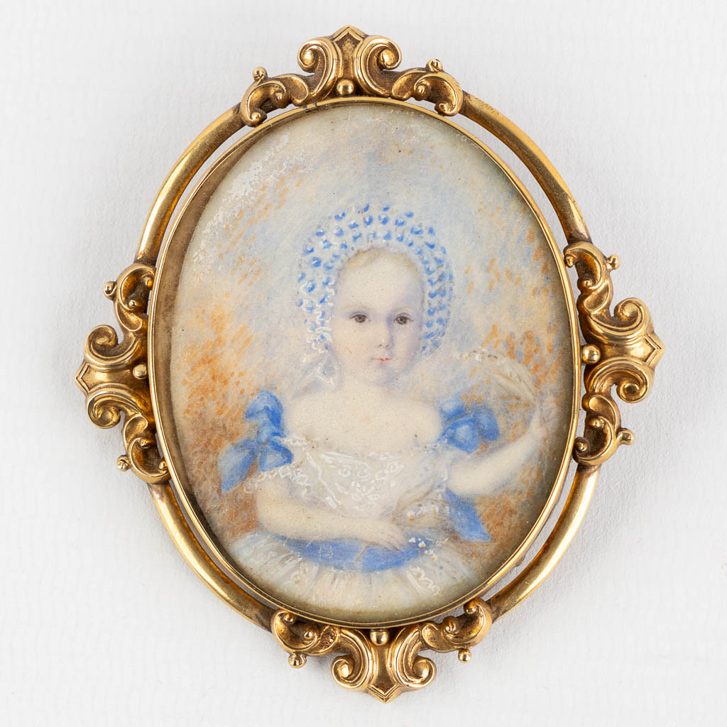 Een broche met miniatuur portret van een kind, 14kt geel goud. (W:6,7 x H:7,8 cm)