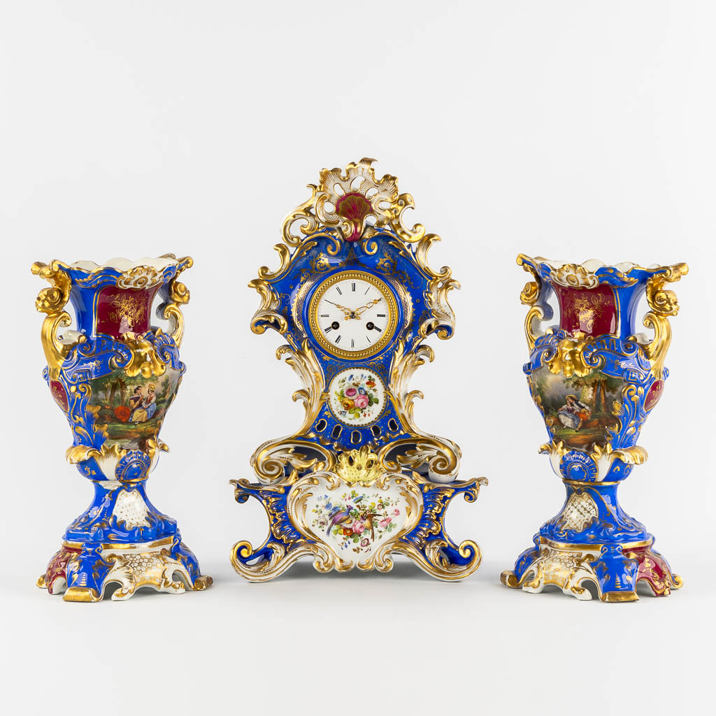 A Vieux Paris mantle clock with two side pieces, in the style of Jacob Petit. 19th C. (L:13 x W:25 x H:41 cm)