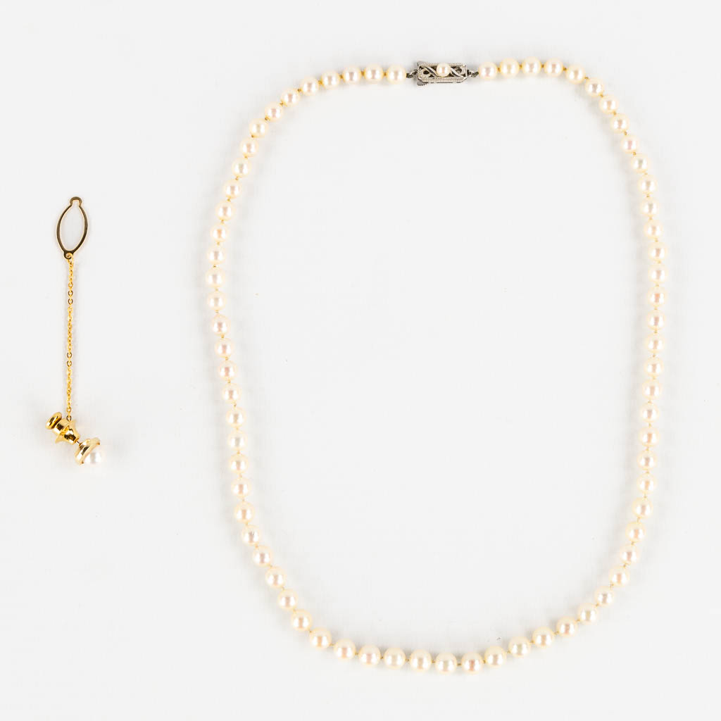 Mikimoto, a pearl necklace and tie clasp, 14kt white and yellow gold, 1965. 