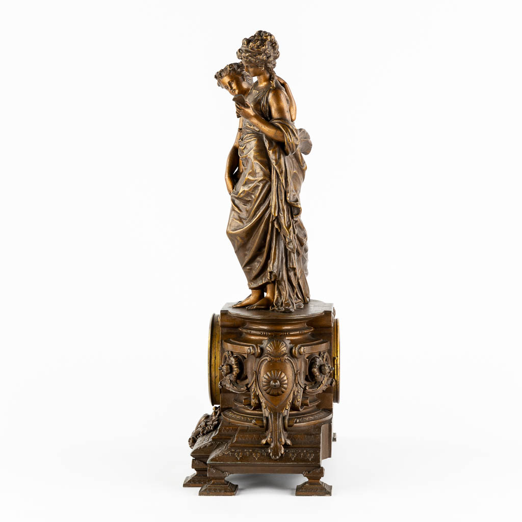 A large mantle clock with two ladies, patinated spelter. Circa 1900. (L:18 x W:42 x H:58 cm)