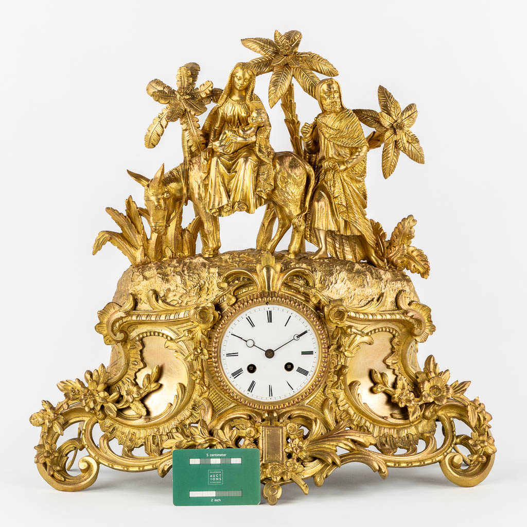 A mantle clock gilt bronze 'The Flight into Egypt'. 19th C.