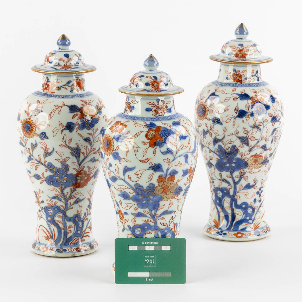 Drie Chinese Imari stijl vazen met een deksel en floraal decor, Kangxi. (H:27 x D:11 cm)