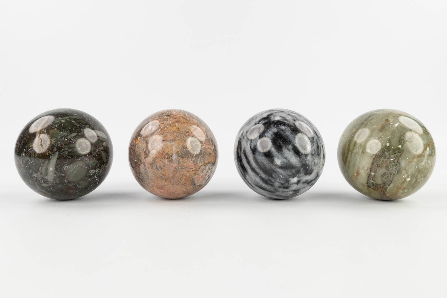 A set of 4 balls made of natural stone and marble. 20th C.  (D:9 cm)