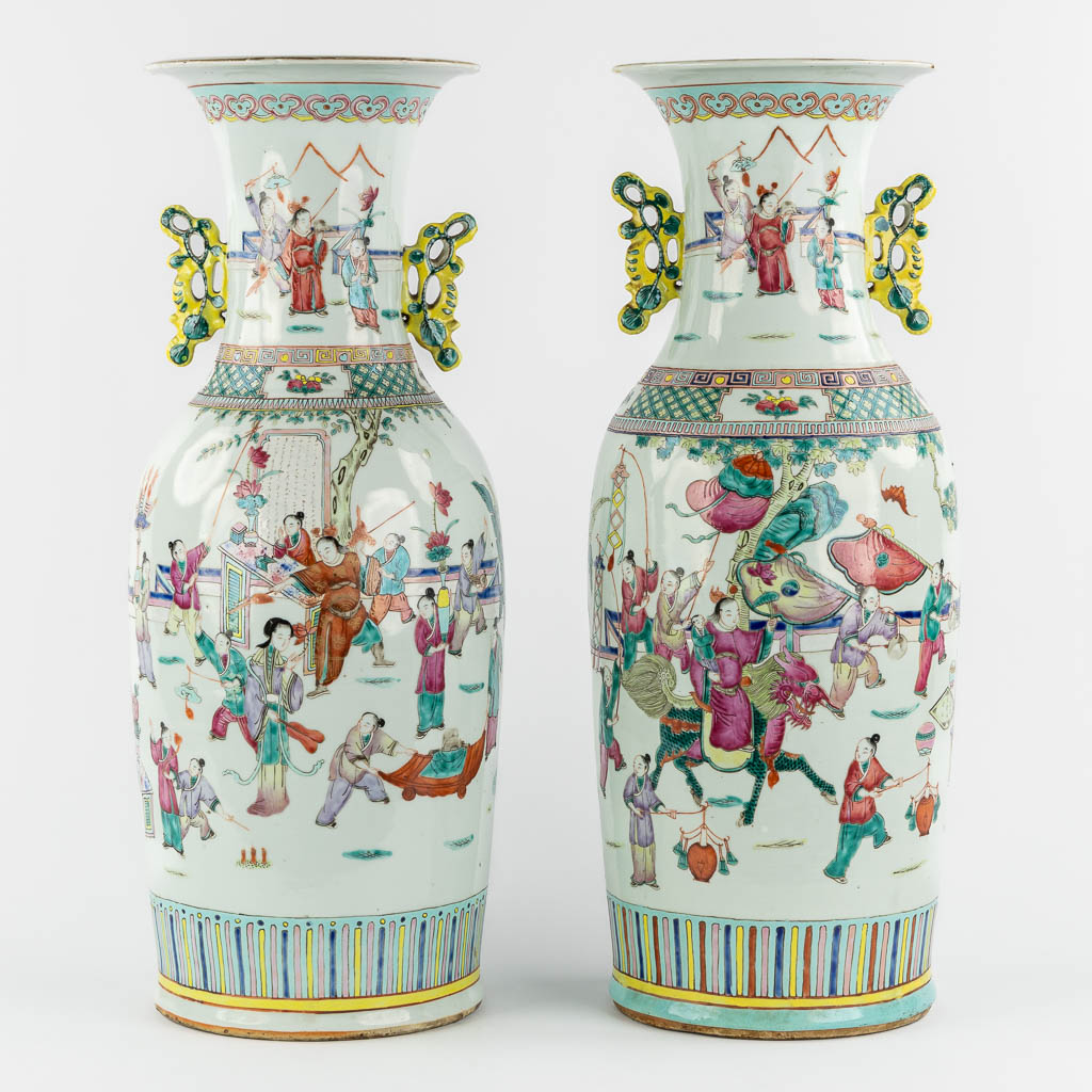 A pair of Chinese Famille Rose vases decorated with various figurines. (H:60 x D:23 cm)