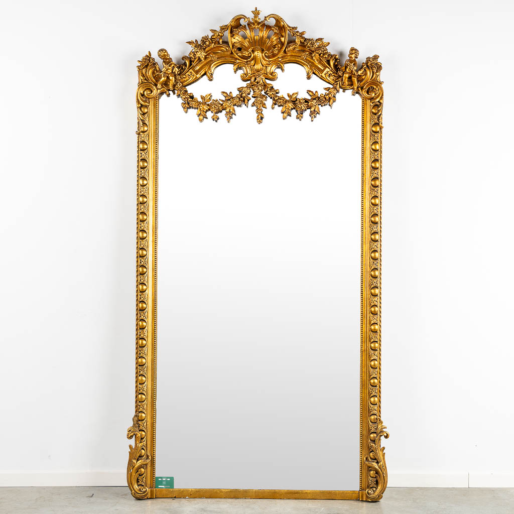 A mirror, sculptured wood, and stucco in a Louis XV style. 20th C. (W:110 x H:218 cm)