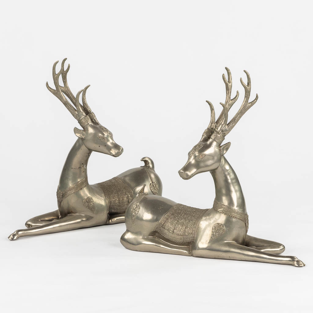 Een paar liggende 'Temple Deer', verzilverd metaal. Circa 1970. (L:22 x W:51 x H:51 cm)