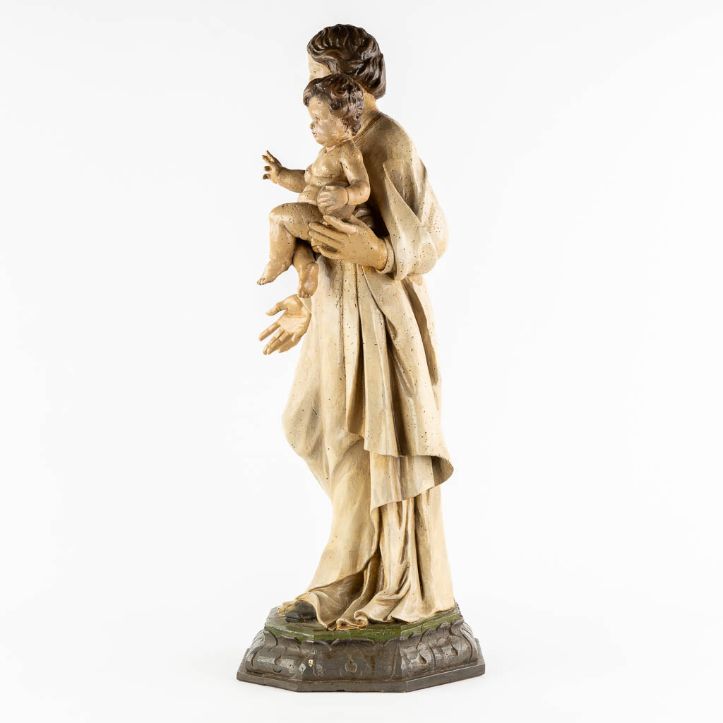 A wood-sculptured and patinated figurine of Madonna with a child. 18th C. (L:33 x W:34 x H:90 cm)