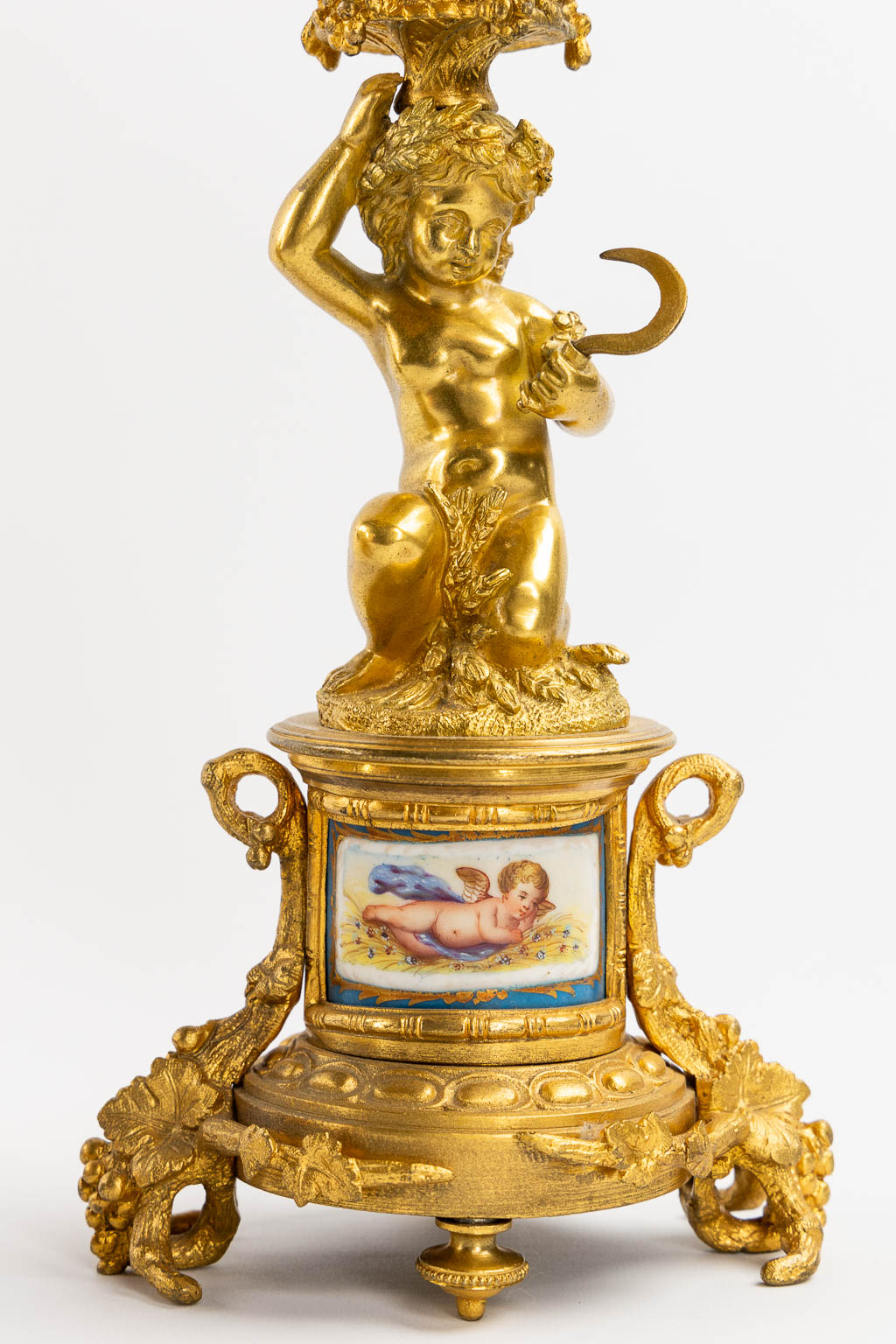 A three-piece mantle garniture clock and candelabra, gilt bronze and Sèvres porcelain, 19th C. (L:20 x W:53 x H:52 cm)