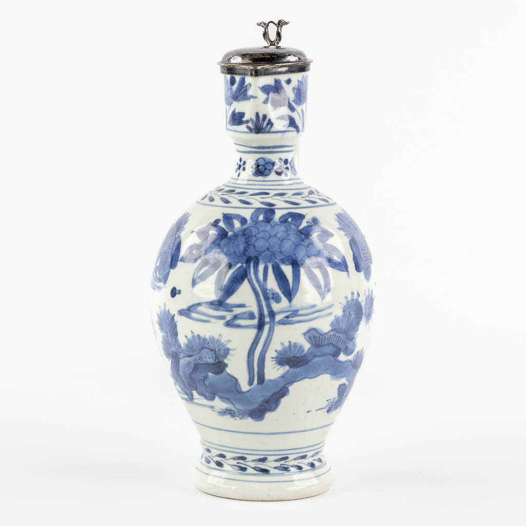 A Chinese pitcher, blue-white mounted with silver, Netherlands, 17th C. (L:12 x W:13 x H:25 cm)