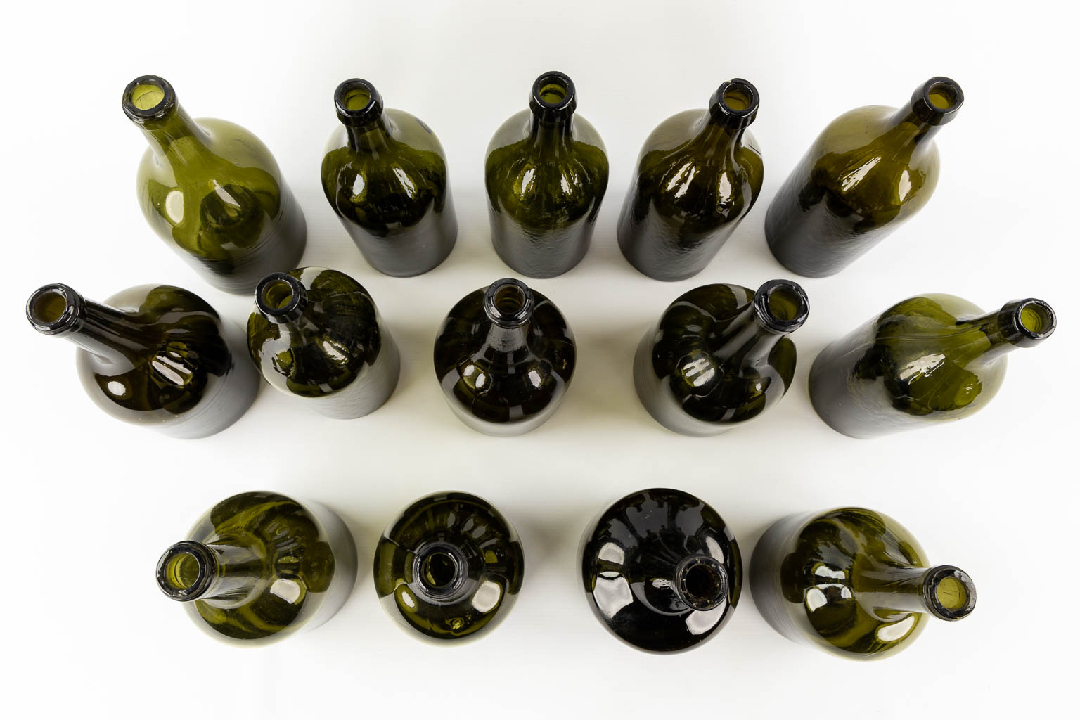 Fourteen antique glass bottles. Olive green glass. 18th and 19th C.