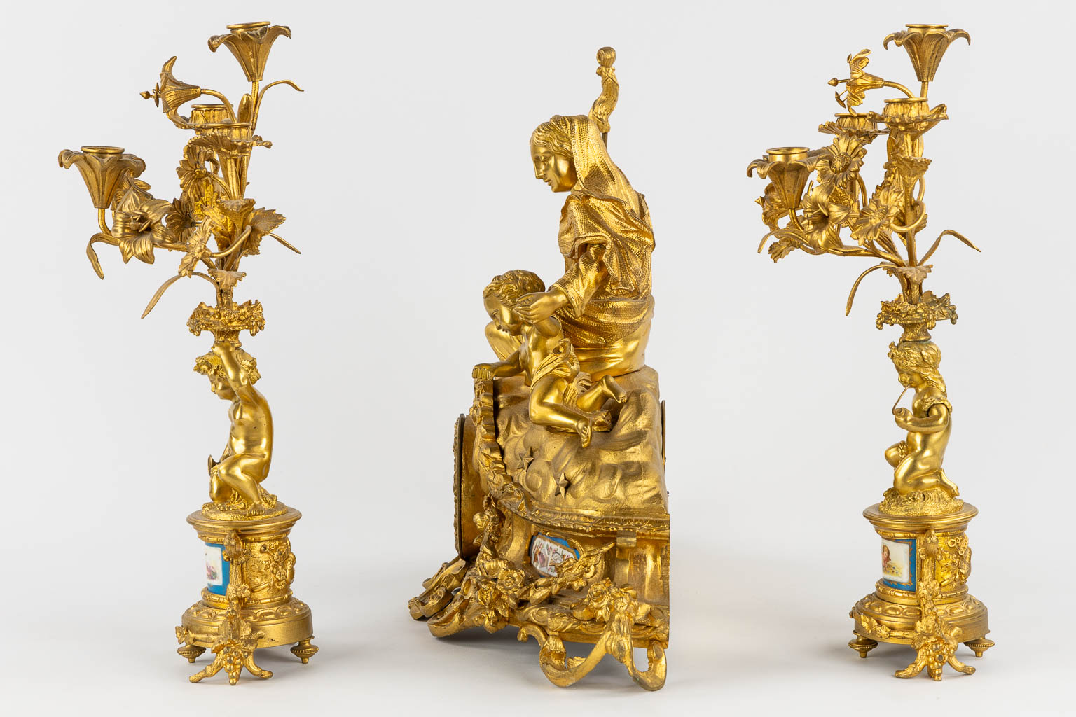 A three-piece mantle garniture clock and candelabra, gilt bronze and Sèvres porcelain, 19th C. (L:20 x W:53 x H:52 cm)