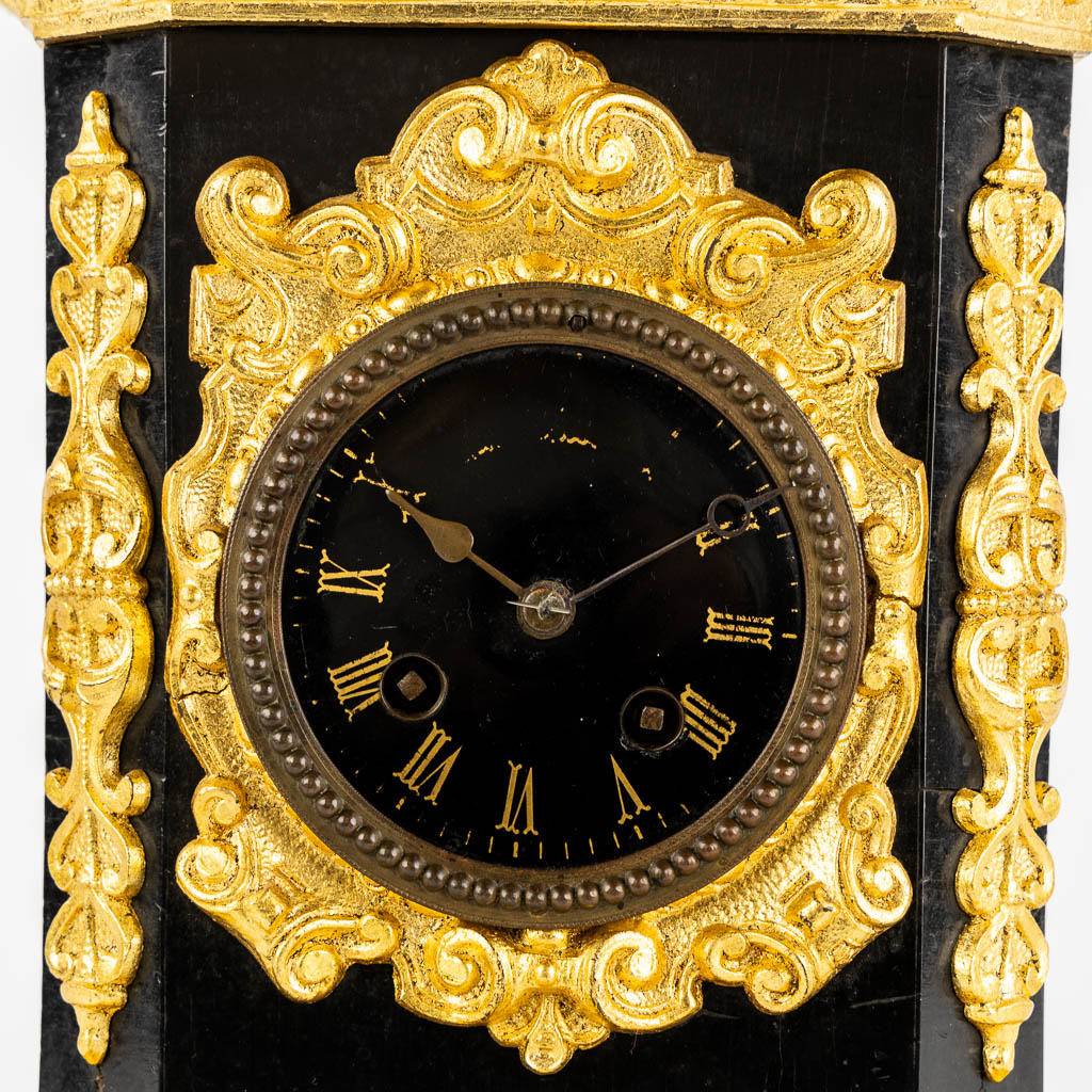 A mantle clock with a 'Hunter', gilt spelter mounted on ebonised wood. 19th C.