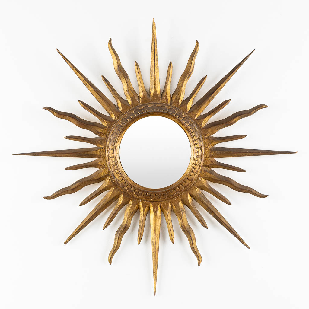 A sunburst mirror, gilt and sculptured wood. (D:66 cm)