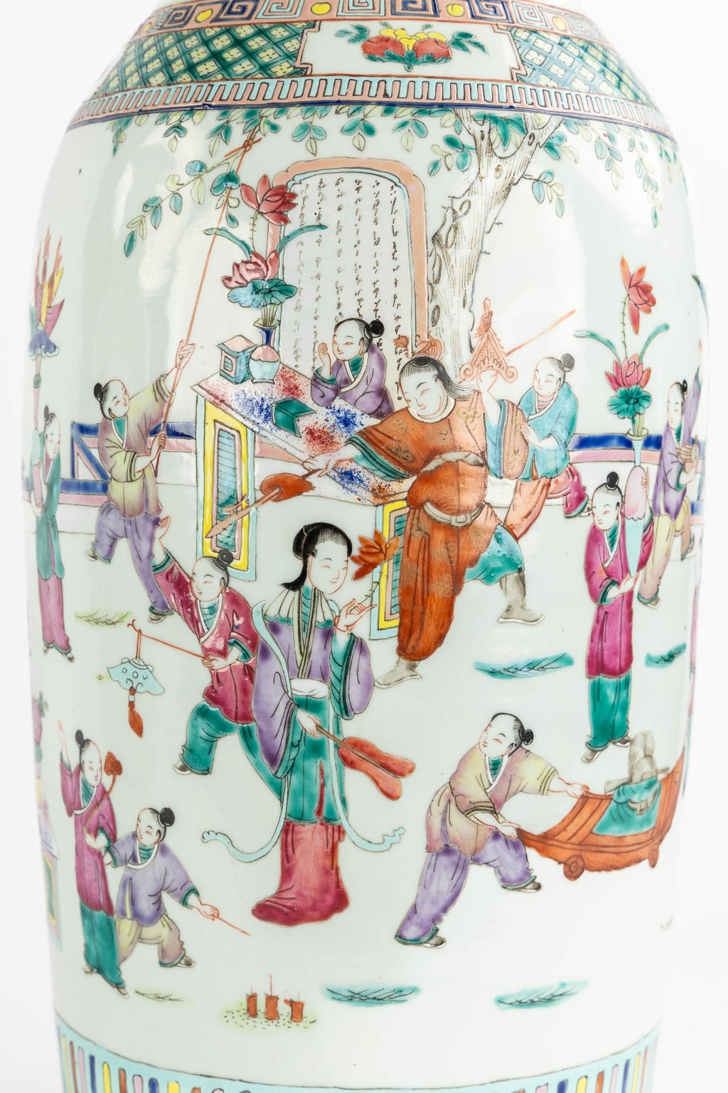 Een paar Chinese Famille Rose vazen, rijk decor met verscheidene figuren. (H:60 x D:23 cm)