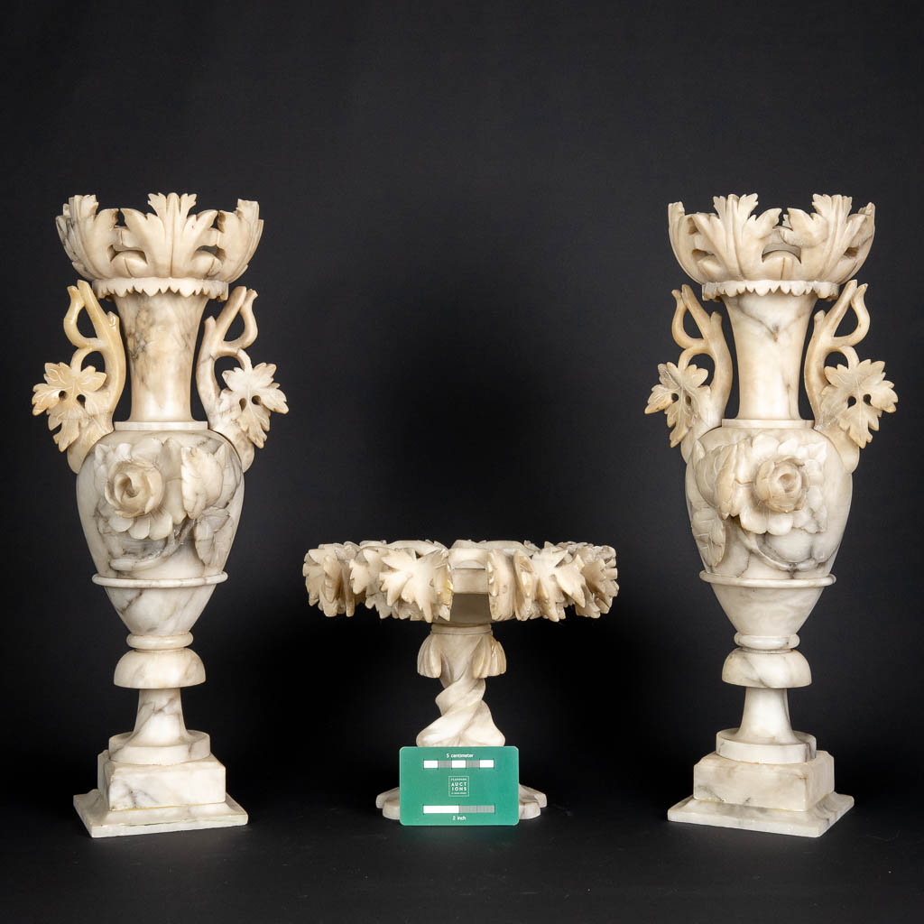 A three piece mantle garniture set, sculptured alabaster. (H:45 x D:15 cm)