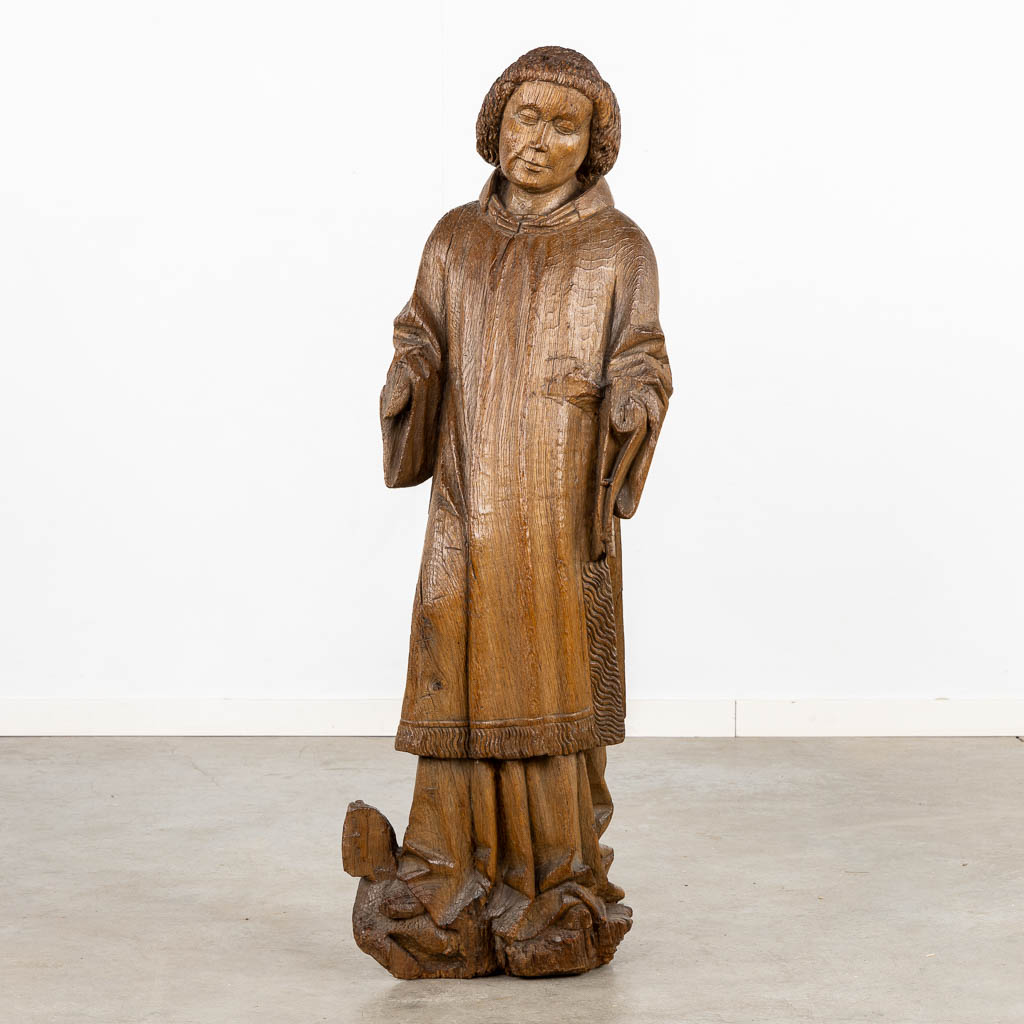 Een antieke houtsculptuur van de Diaken Laurentius, Gotisch, circa 1400. (L:22 x W:36 x H:117 cm)