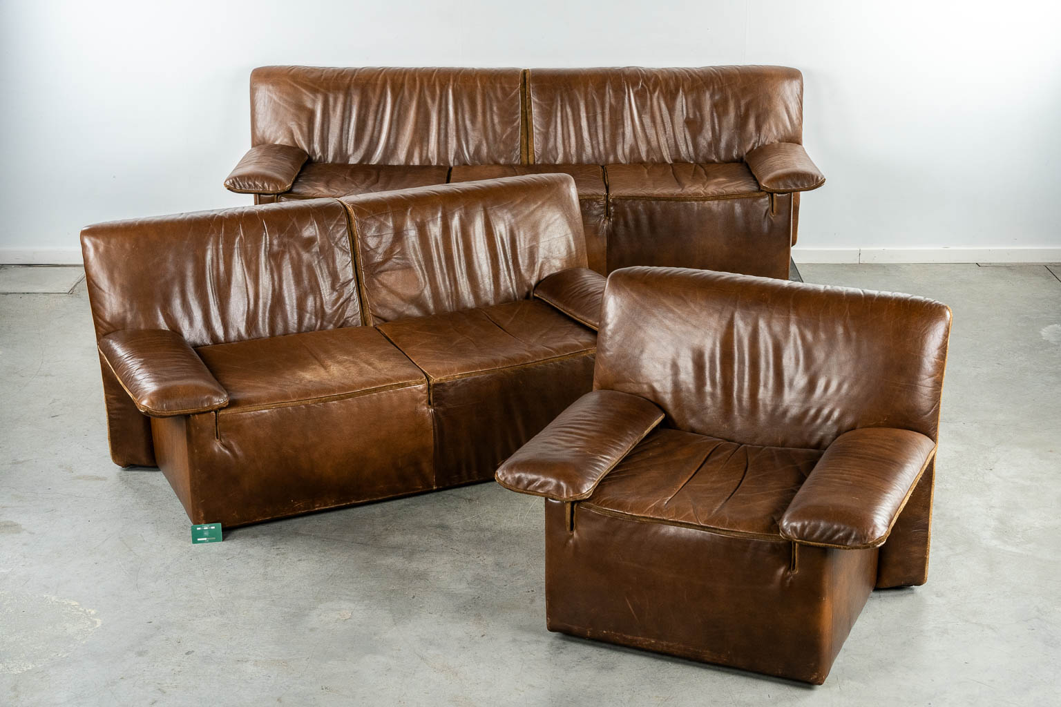 Jori, a three-piece salon suite, brown leather. (L:90 x W:235 x H:78 cm)