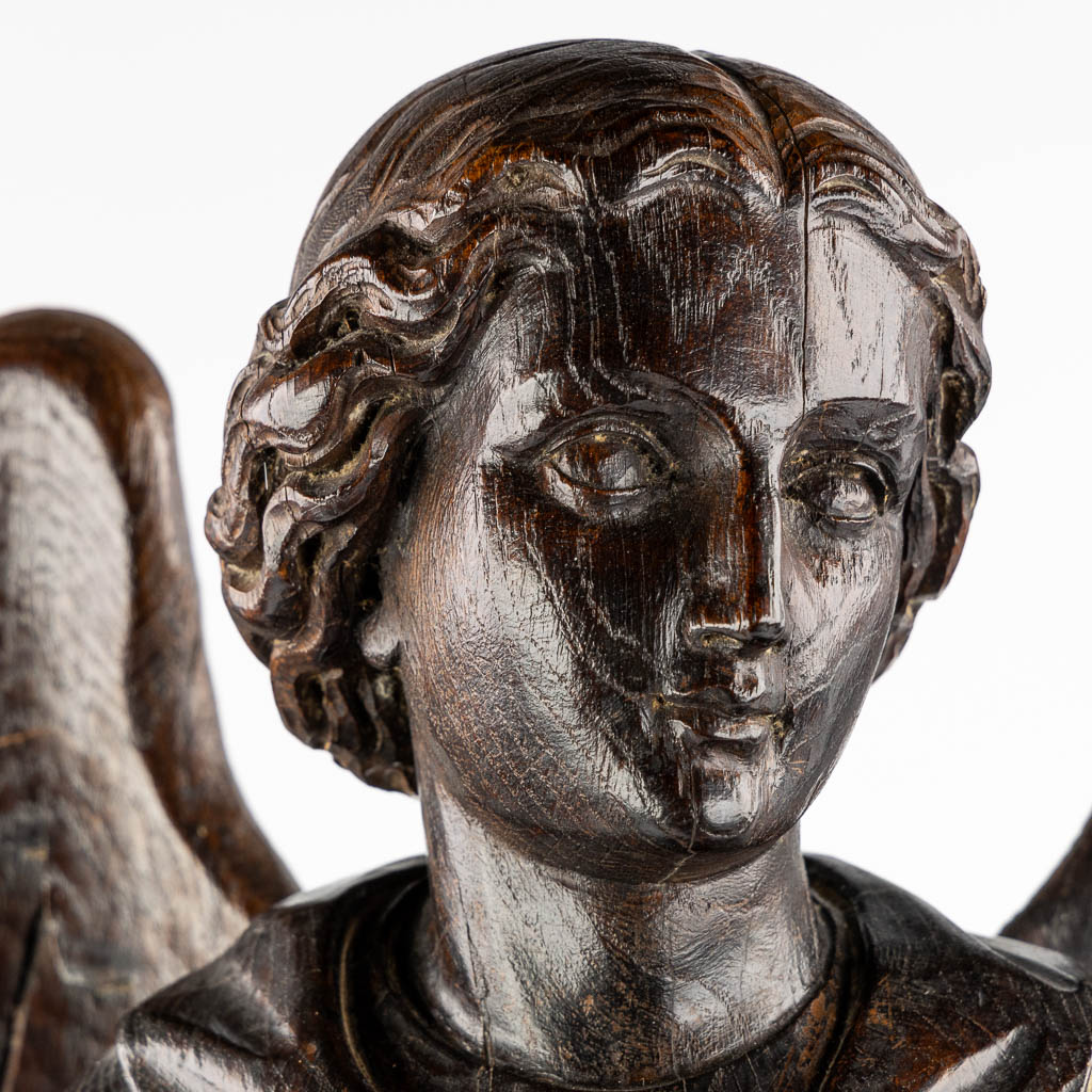 A large wood sculptured figurine of an angel, oak, 19th C. (L:20 x W:40 x H:95 cm)