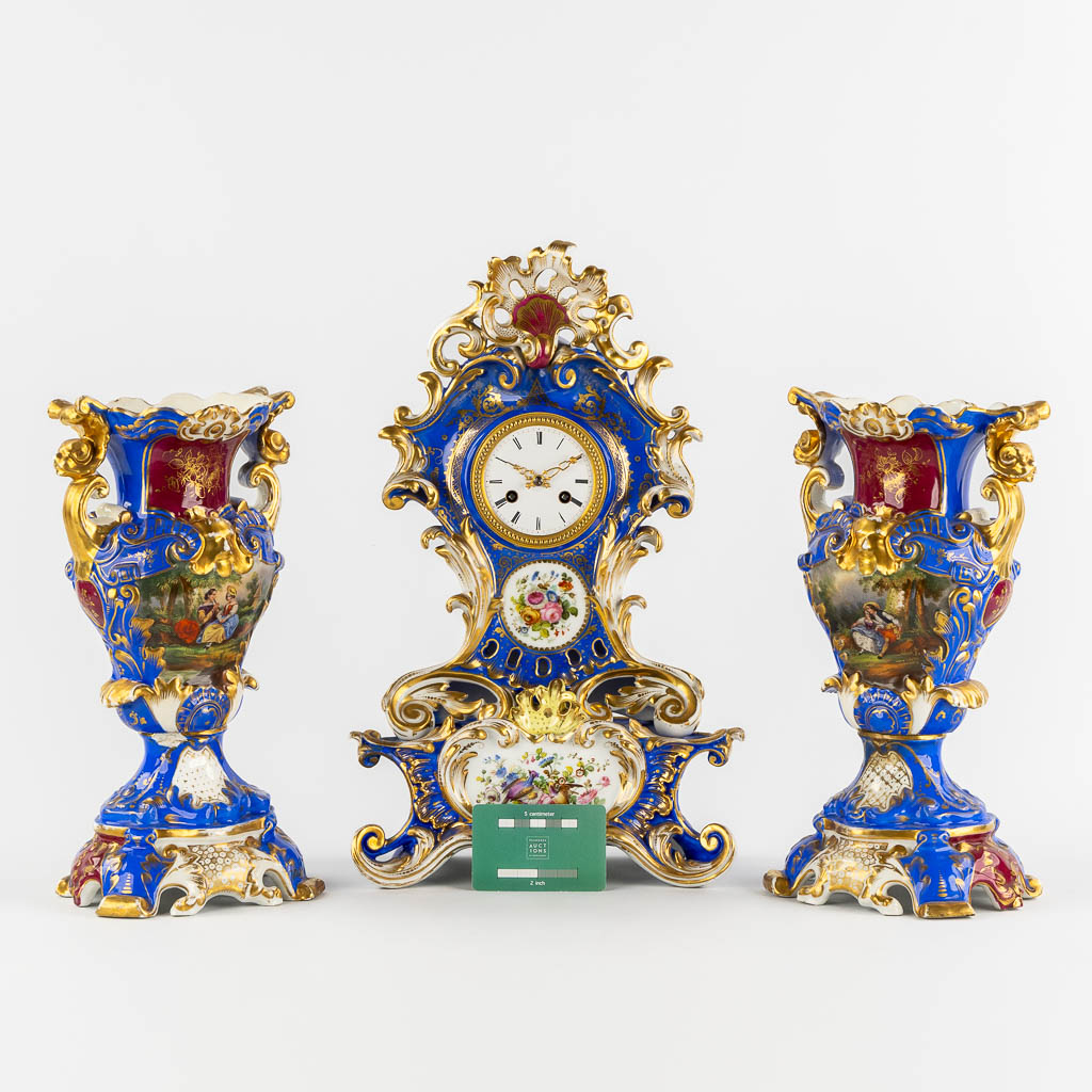 A Vieux Paris mantle clock with two side pieces, in the style of Jacob Petit. 19th C. (L:13 x W:25 x H:41 cm)