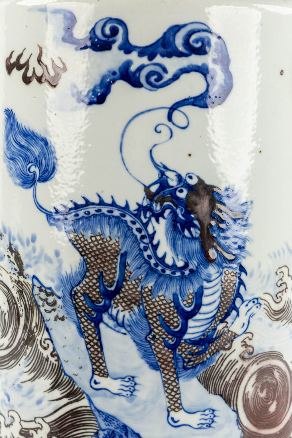 A Chinese Rouleau vase with a blue, black and white Foo Dog. Kangxi mark, 19th C. (H:39 x D:29 cm)